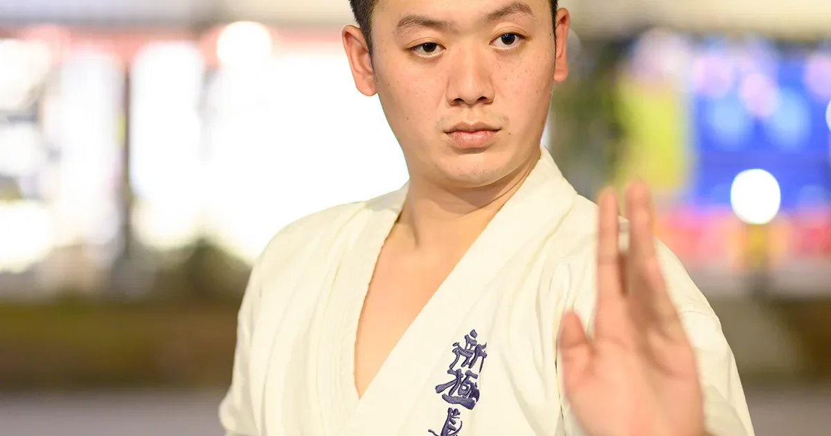 IMAC Dojo の稽古生が、新極真会の空手衣で素手の構えを取っている様子。