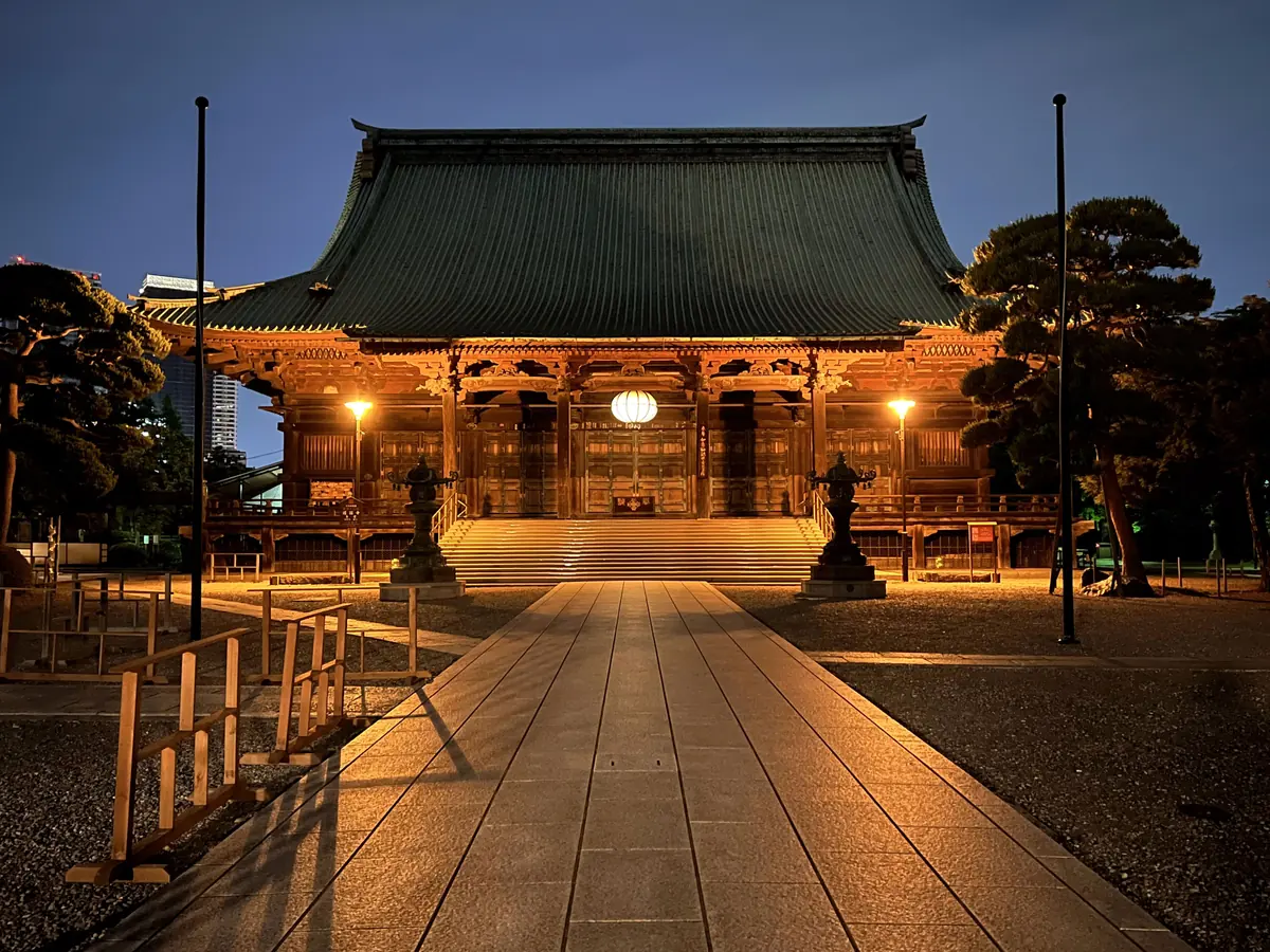 The Kannon-do hall of Gokoku-ji lit at dusk, with a stone path leading to it