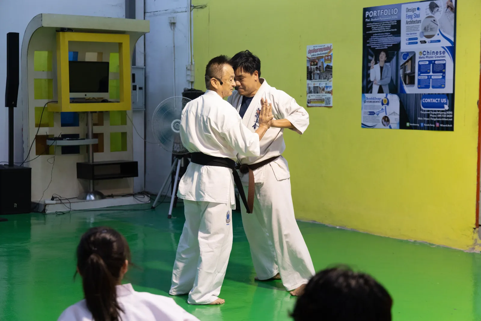 Shihan Nagashima และครูสายน้ำตาลยืนประชิดตัว ใช้ฝ่ามือดันกันเพื่อทดสอบสมดุล