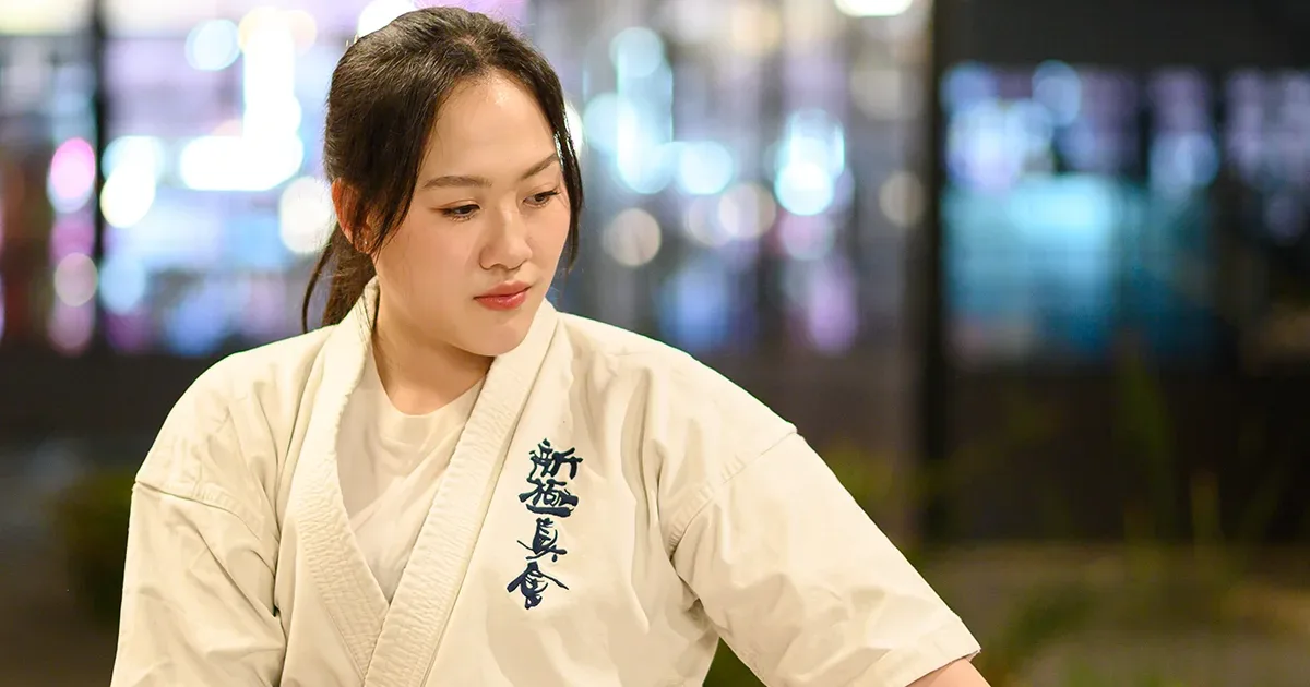 นักเรียนหญิงของ IMAC Dojo ในชุดคาราเต้ Shinkyokushin สายดำ กำลังอยู่ในท่าฝึกด้วยสีหน้าจดจ่อ
