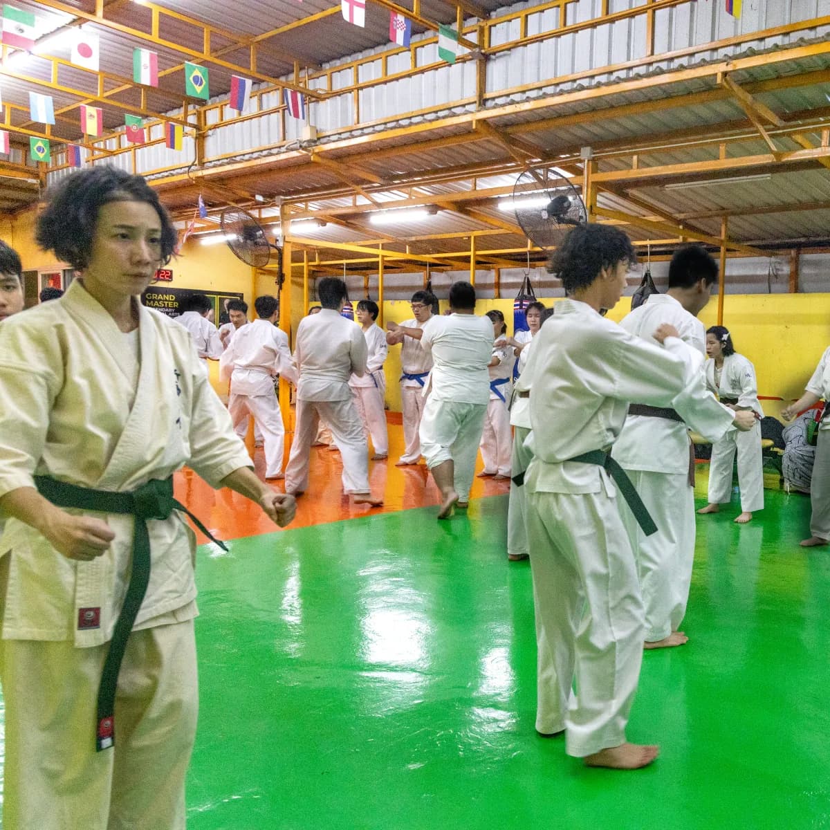 บรรยากาศเต็มพื้นที่ฝึกระหว่างการสอบเลื่อนสายคาราเต้ Shinkyokushin ที่ IMAC Dojo