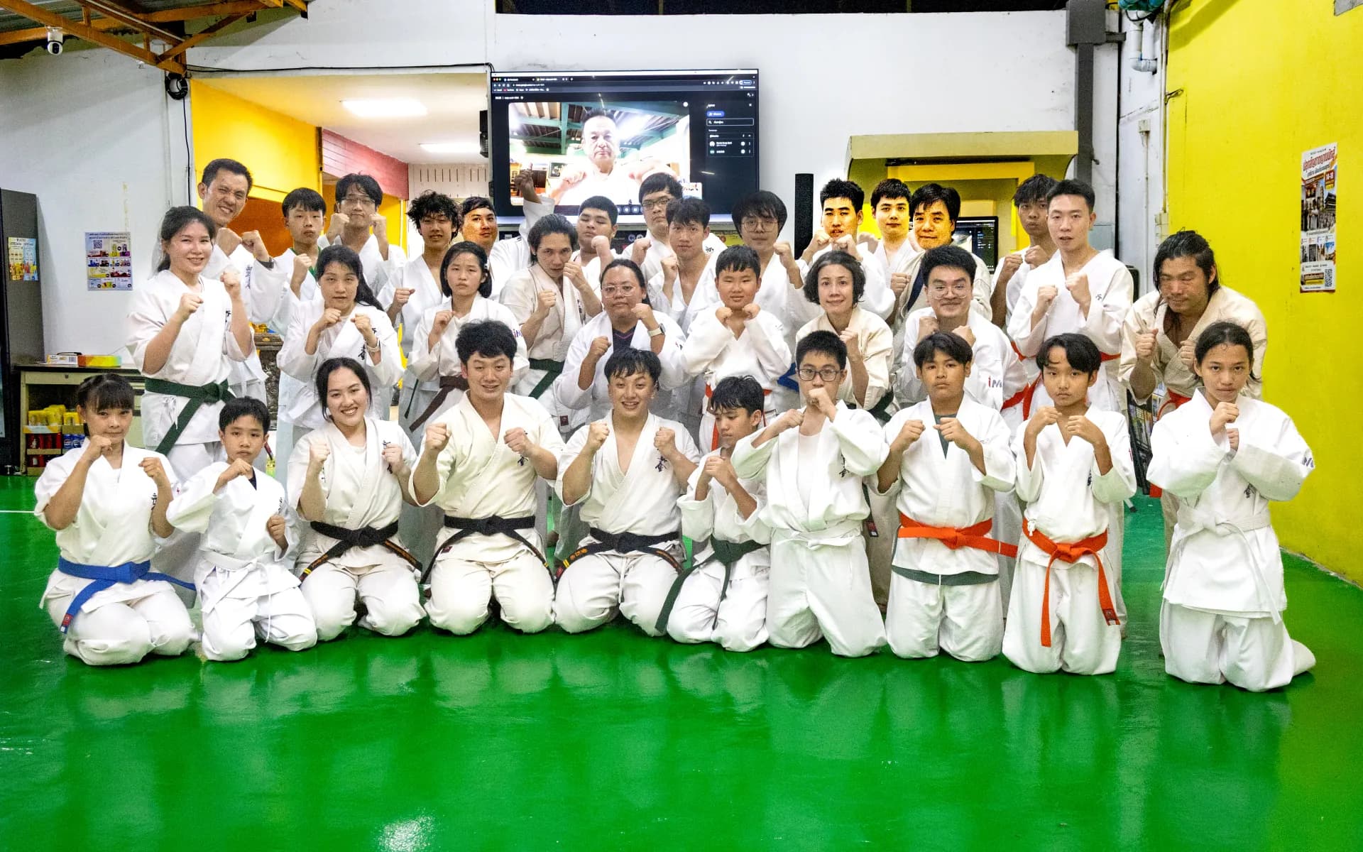 ผู้เข้าสอบและครูผู้สอนถ่ายภาพหมู่หลังการสอบเลื่อนสายคาราเต้ Shinkyokushin ที่ IMAC Dojo